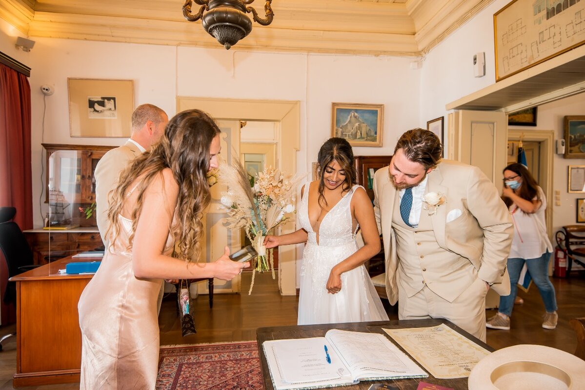a newlywed couple signing their weddig certificate in the Town hall after their civil wedding in Mykonos