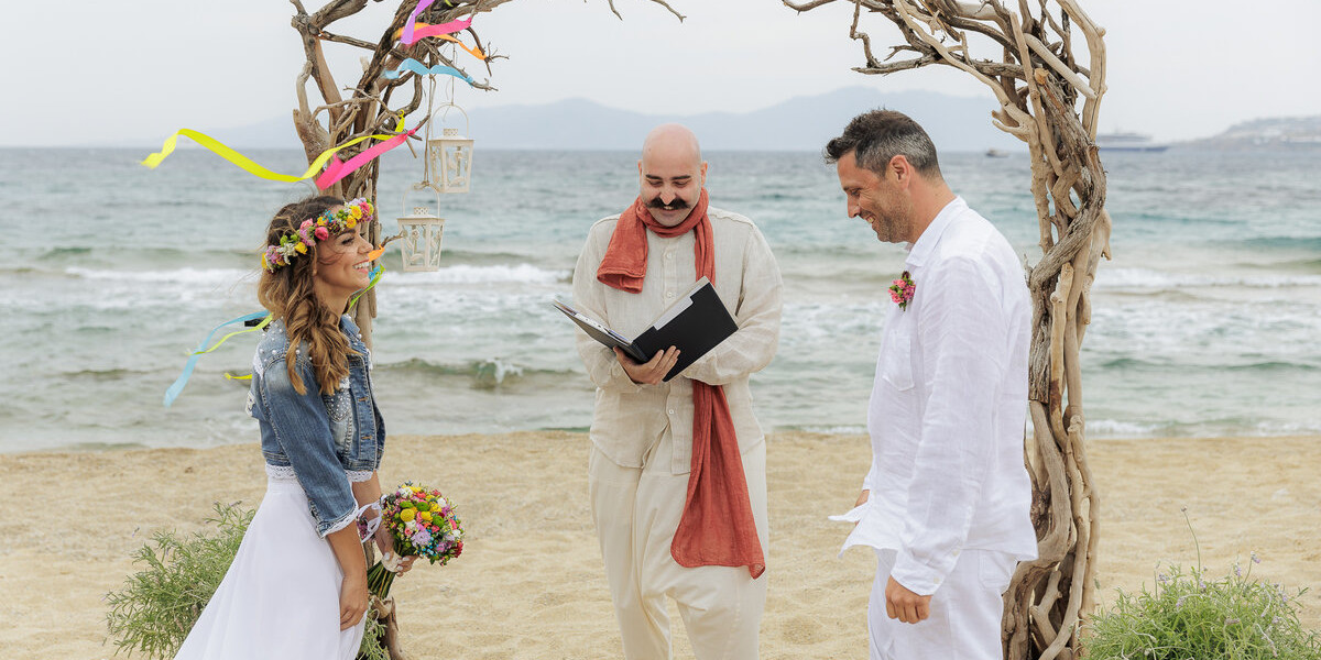 A couple getting married on a beach in Mykonos wedding packages
